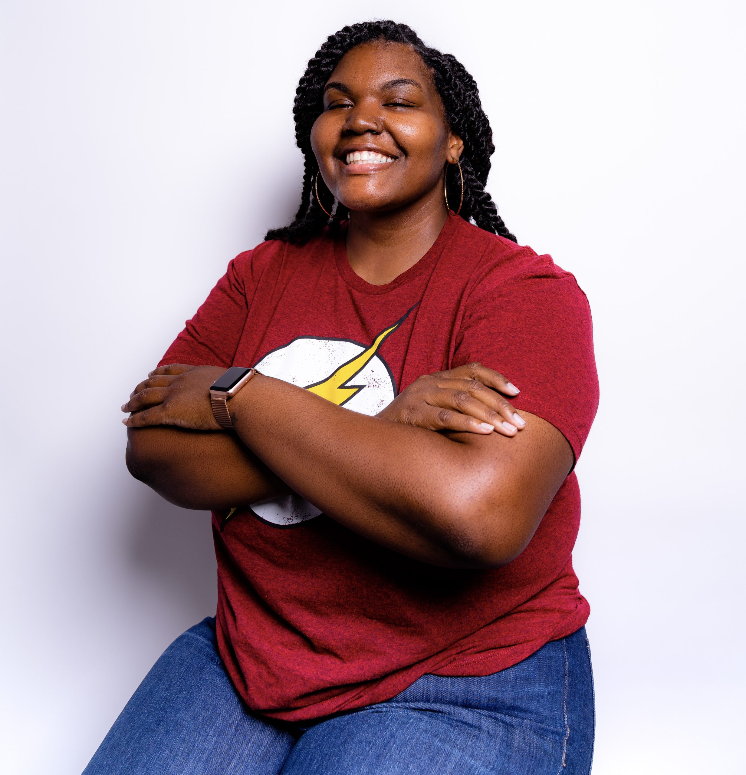 a photo of alexa owens in red tee shirt with flash logo hands are crossed and she is smiling